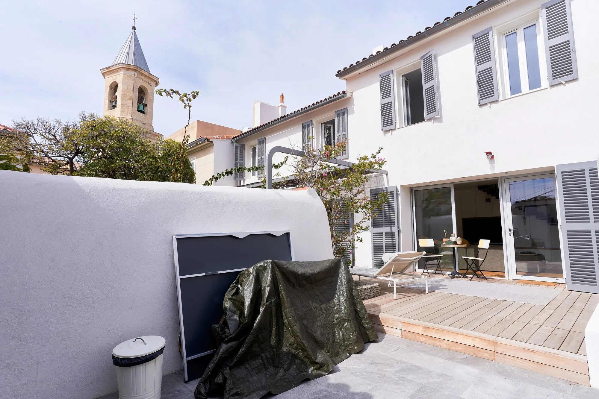 Cour avec terrasse bois et clocher d’Endoume en fond