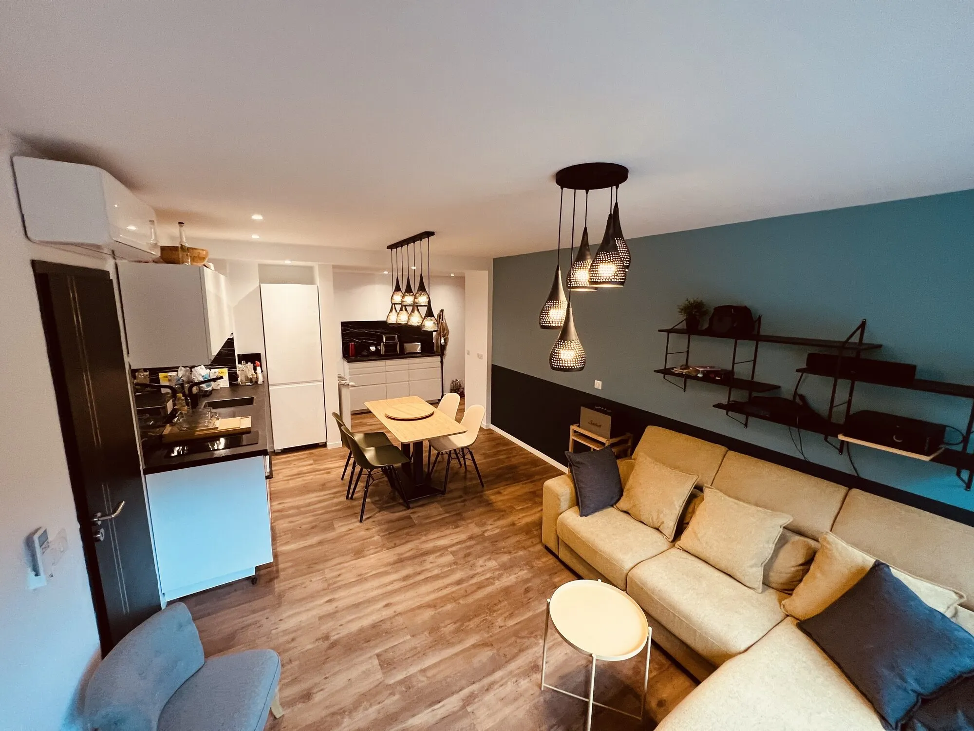 Salon avec mur bleu canard et canapé
