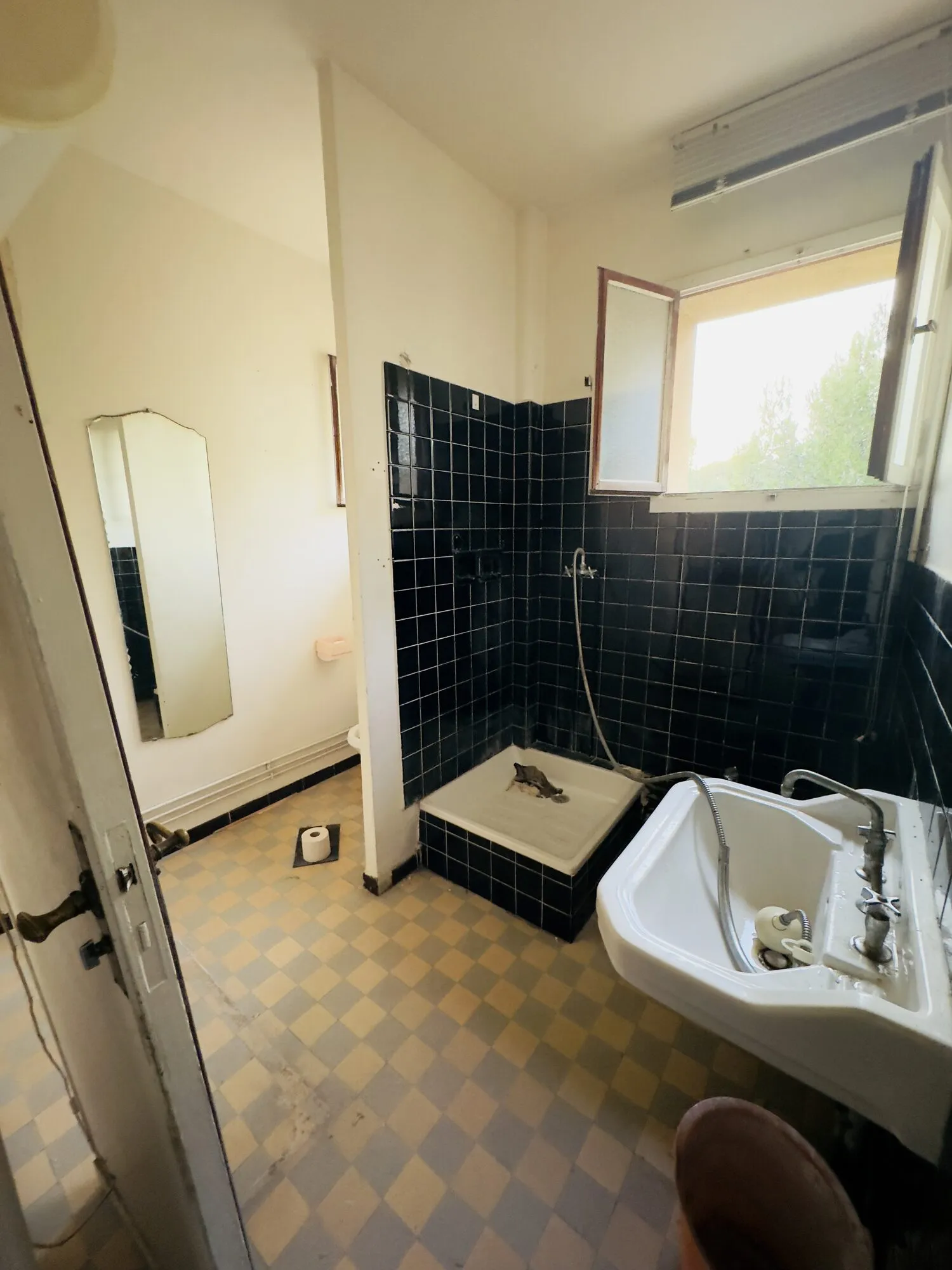 Ancienne salle de bains avec carrelage foncé