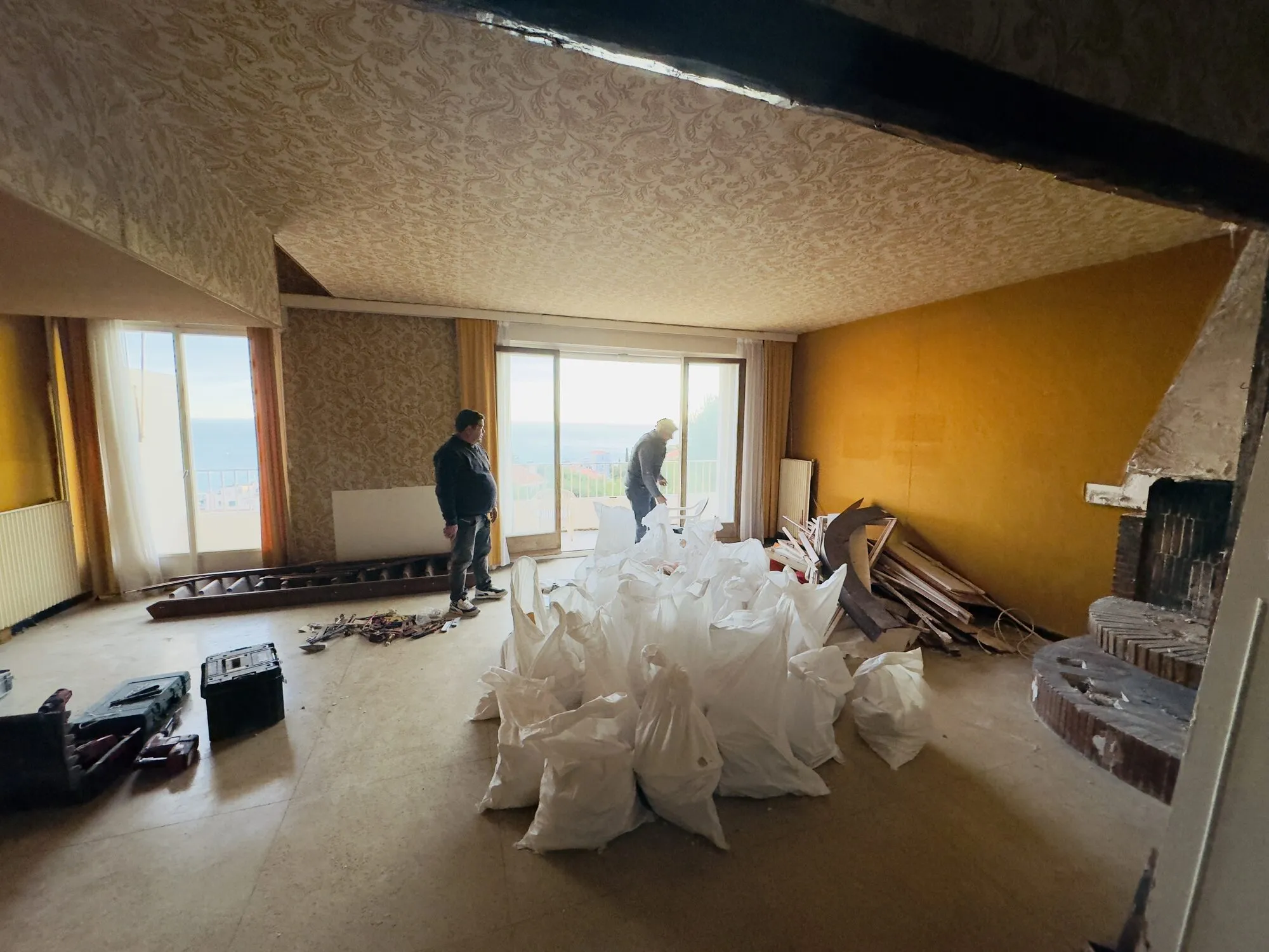 Séjour avant travaux, sacs de gravats au sol