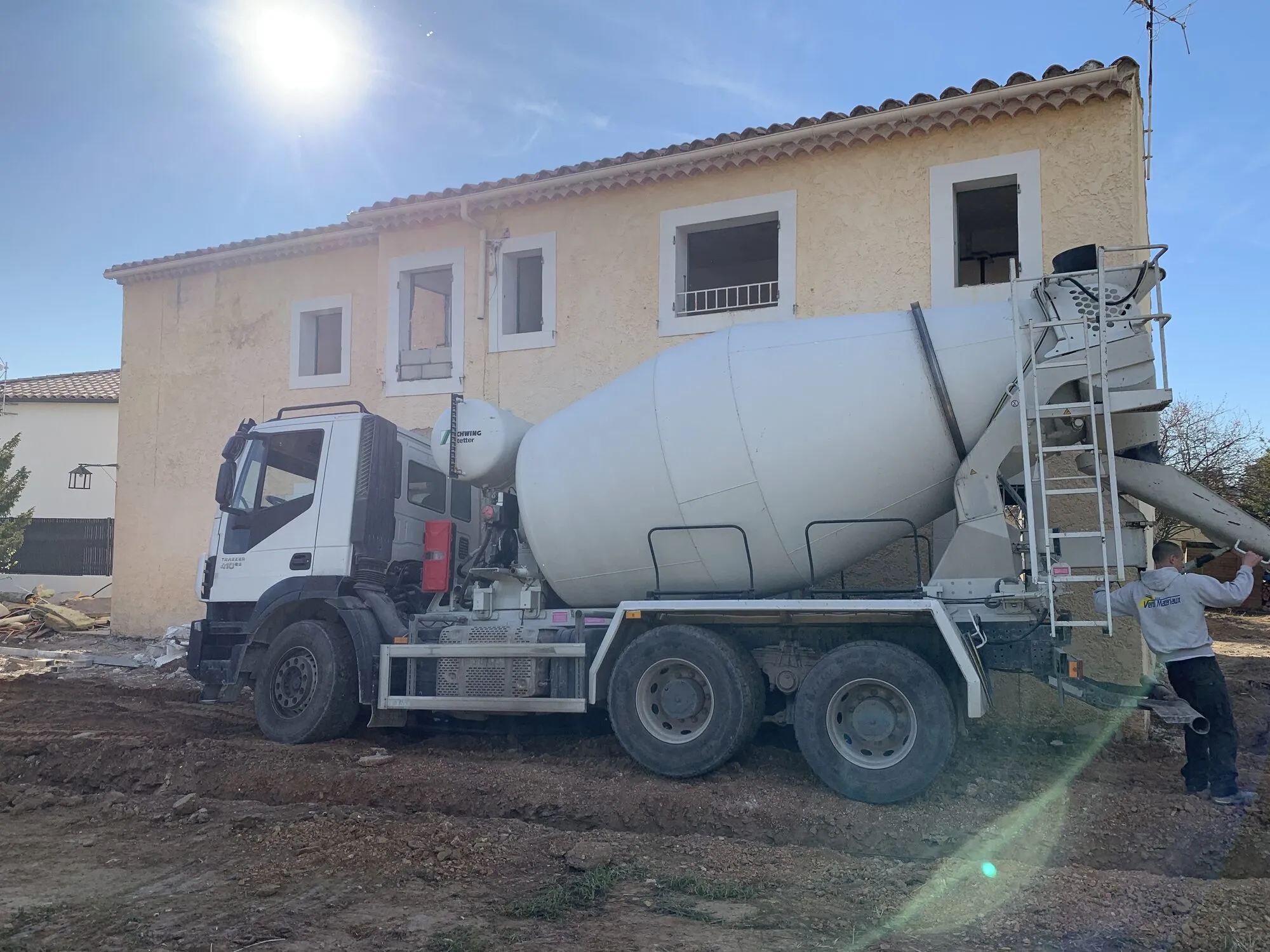 Camion toupie livrant le béton devant la maison