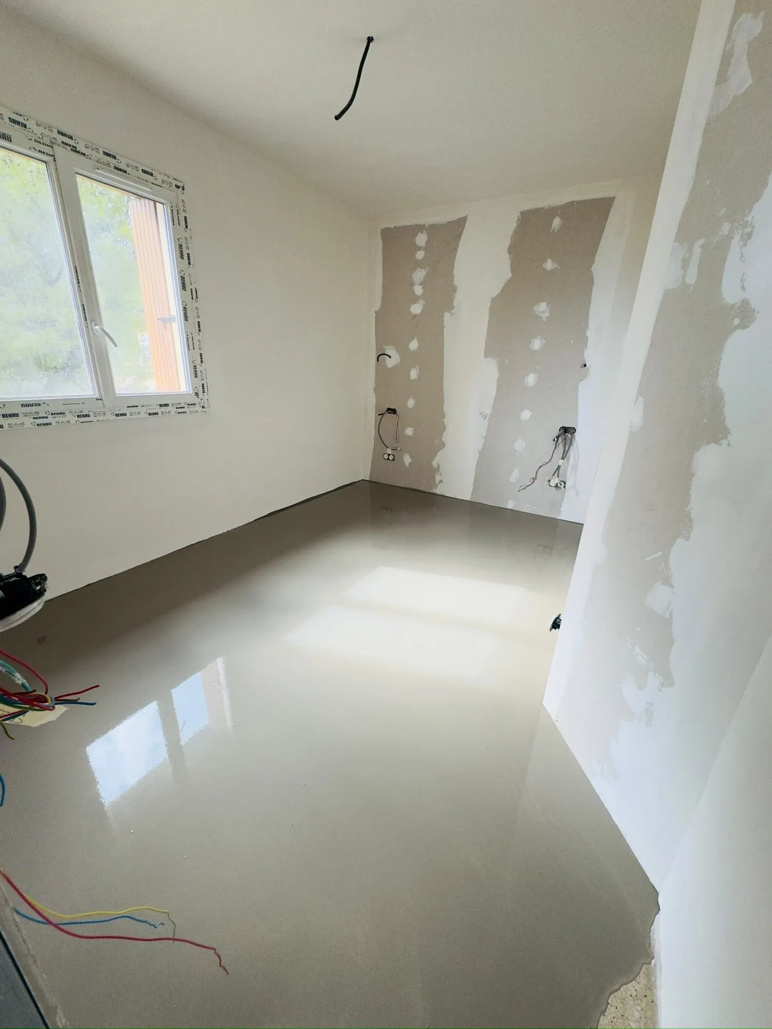 Chape fraîchement coulée dans un séjour en rénovation