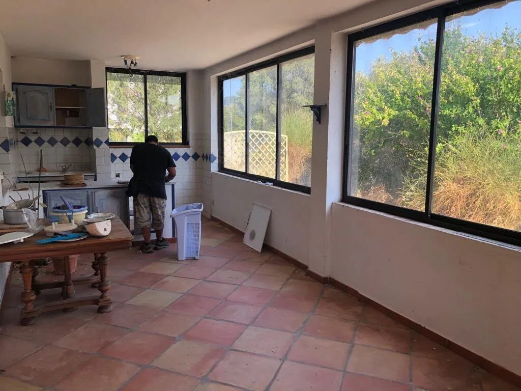 Ancienne cuisine fermée avec carrelage en terre cuite, avant rénovation